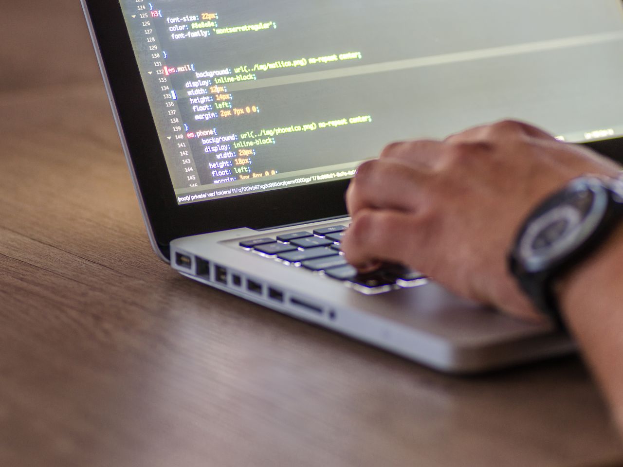 A Purple Brick Devs developer writing code on a laptop