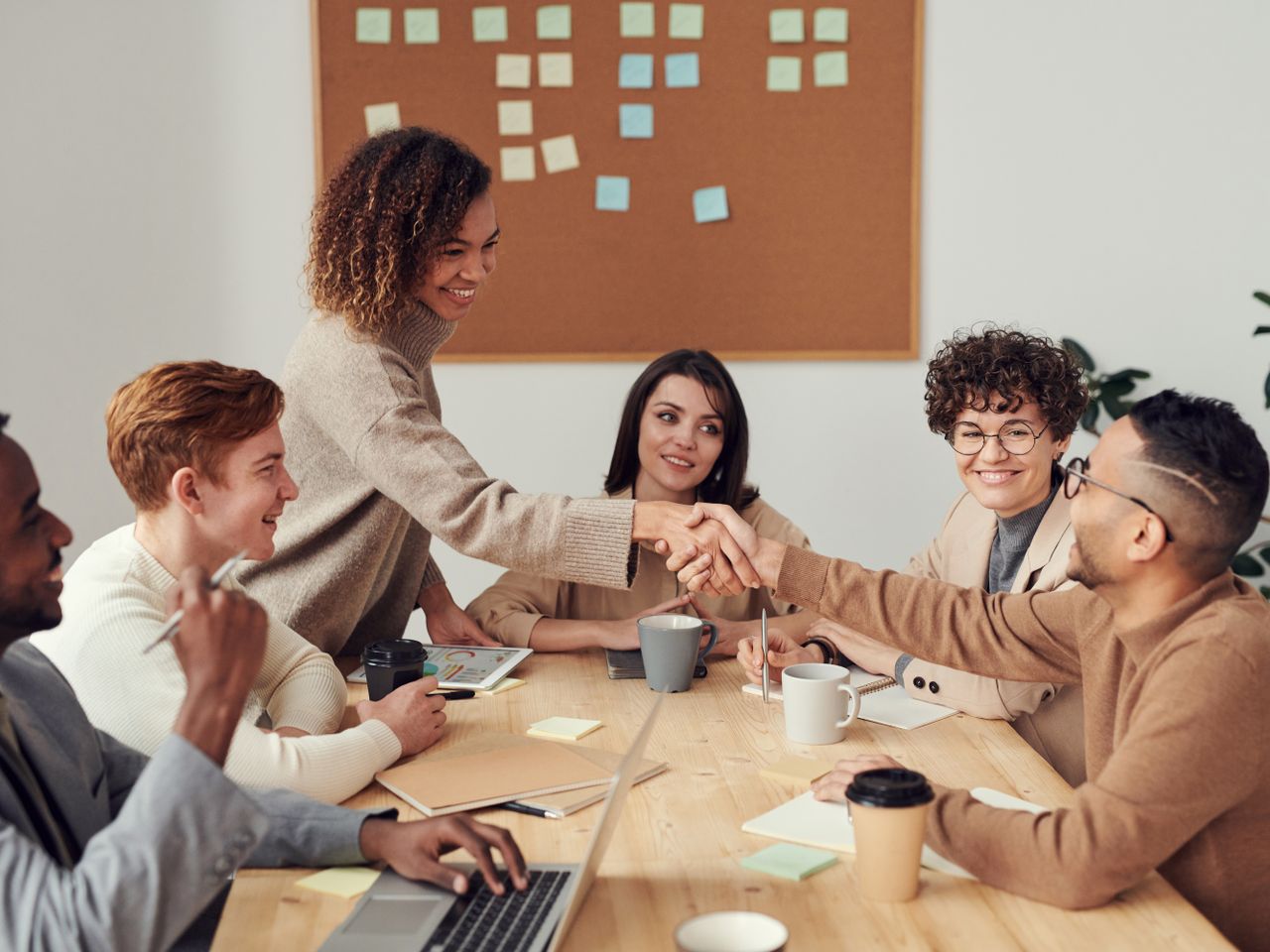 Purple Brick Devs team collaborating and shaking hands in a meeting